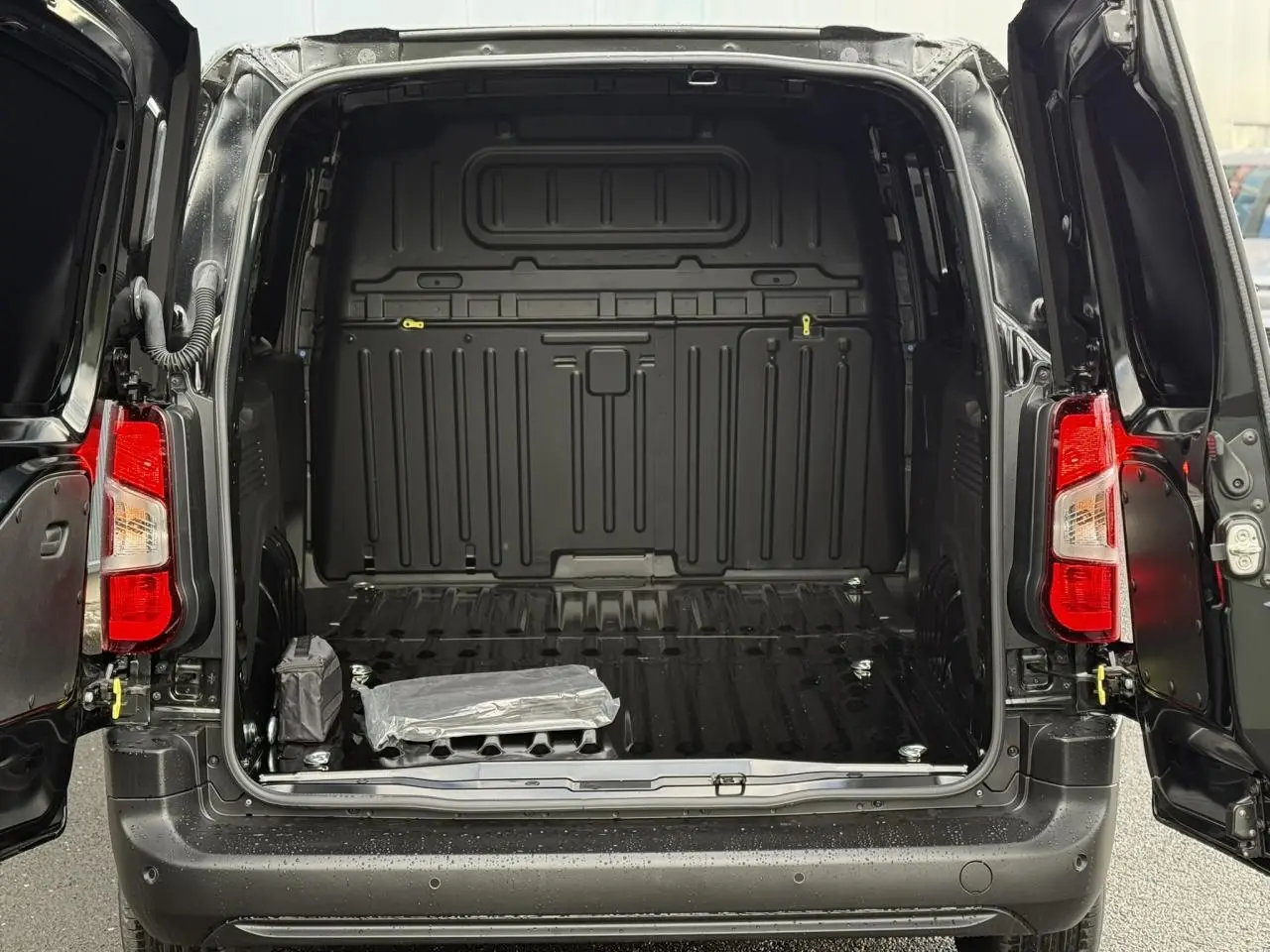 Coffre ouvert d'un Citroën Berlingo Van noir Perla 2025, montrant l'espace de chargement vide avec portes arrière battantes.