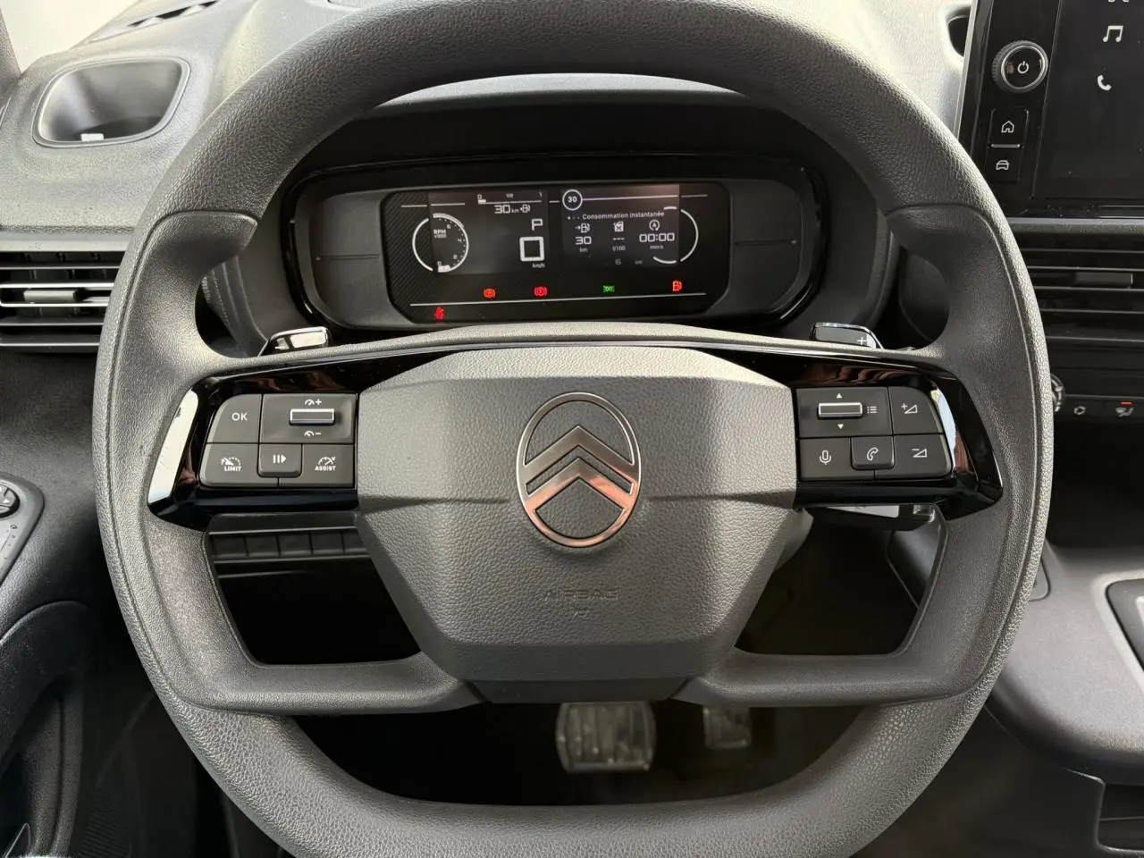 Vue rapprochée du volant multifonctions noir et du tableau de bord numérique du Citroën Berlingo 2025 Van M.