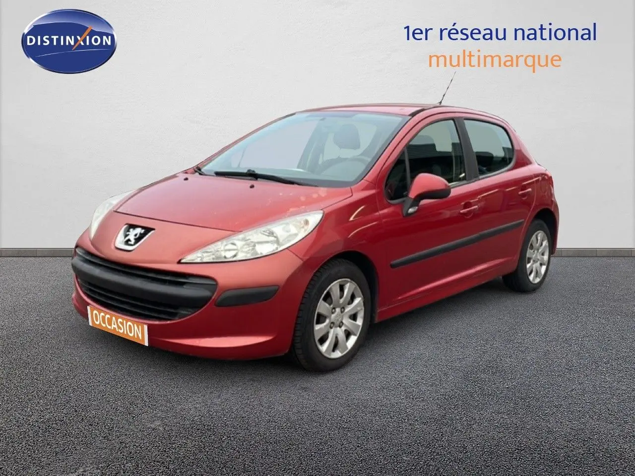 Peugeot 207 rouge métal vue 3/4 avant droit, compacte 5 portes avec baguettes latérales noires.