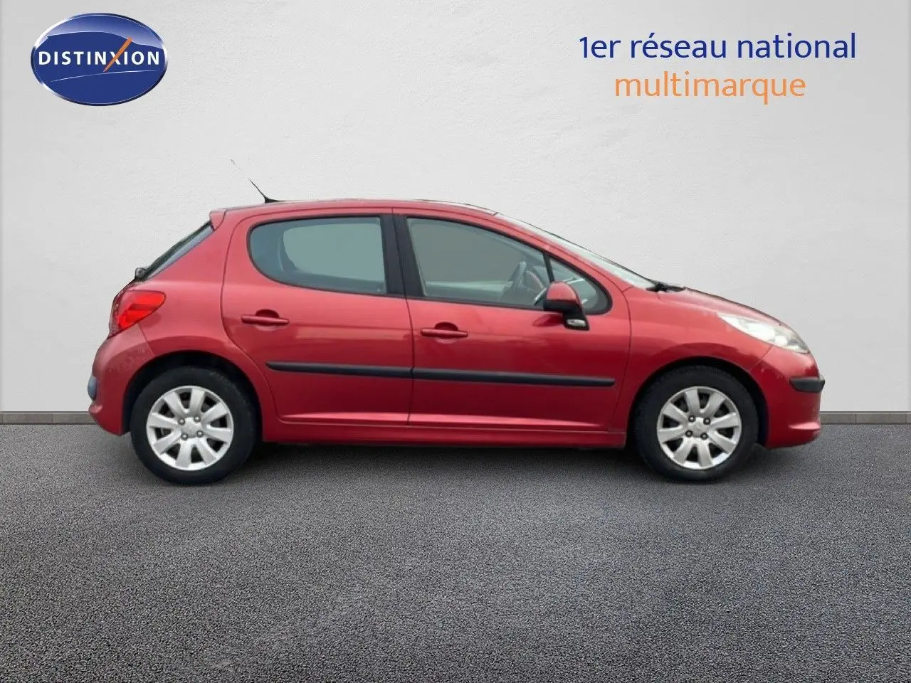 Profil côté gauche d'une Peugeot 207 rouge métal cinq portes de 2009, finition HDI 70CH TREND diesel.