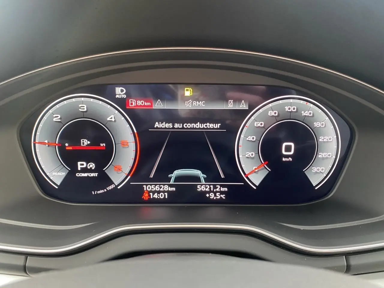 Vue rapprochée du tableau de bord numérique de l'Audi Q5 2022, affichant les aides au conducteur et la vitesse à 0 km/h.