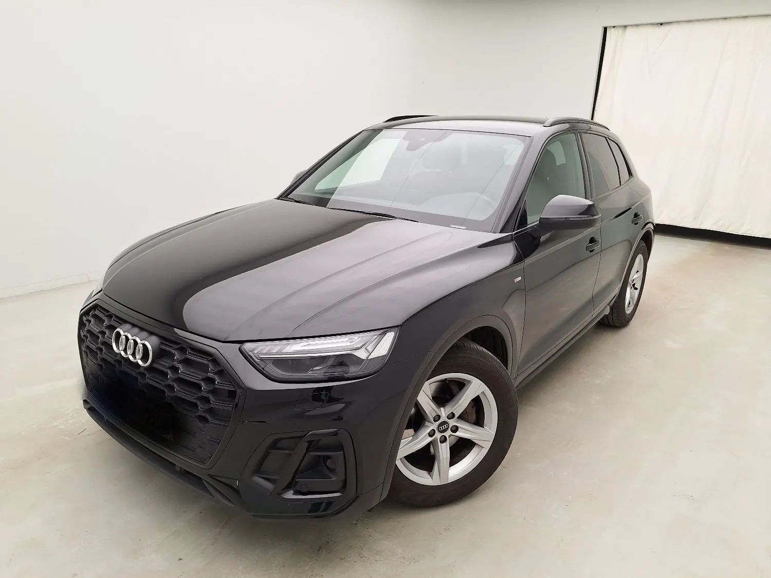 Audi Q5 Business Edition S-Line noir, vue 3/4 avant droit, avec calandre noire et jantes 5 branches argentées.
