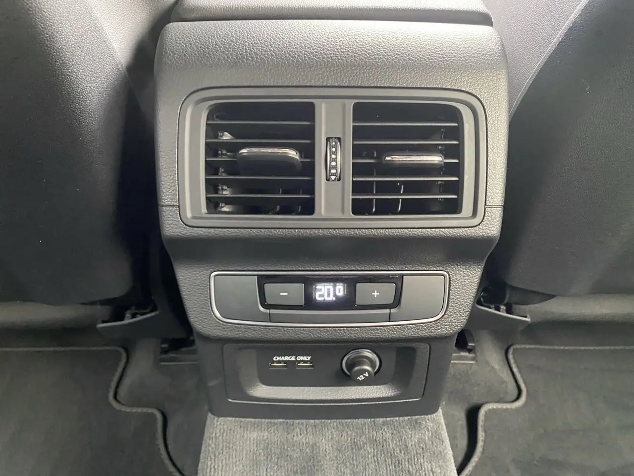 Vue rapprochée de la console arrière noire de l'Audi Q5 2022 avec sorties d'air, réglage climatisation et ports USB.
