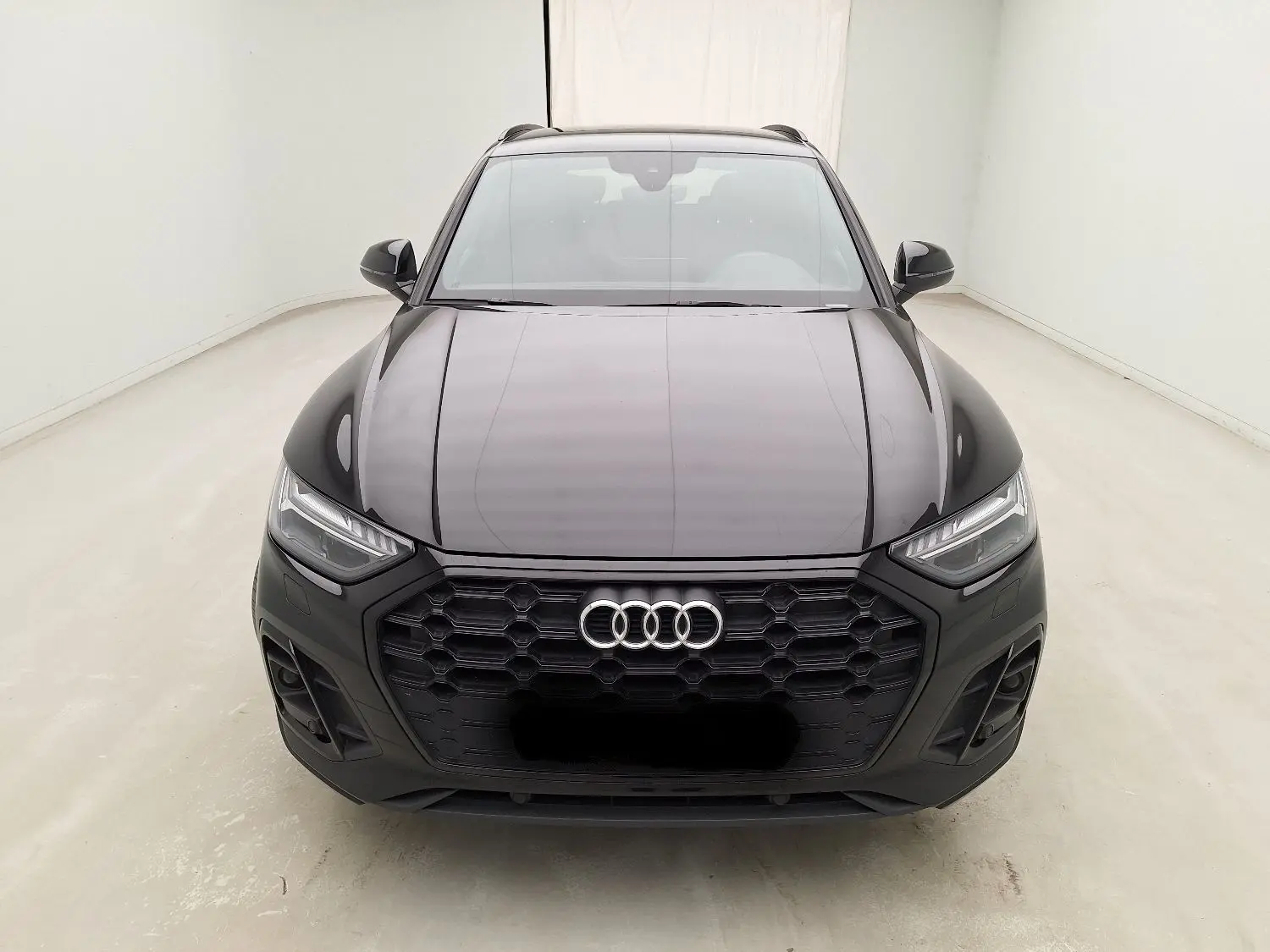Audi Q5 Business Edition S-Line noir vue de face, mettant en valeur la calandre hexagonale et les phares LED à matrice.