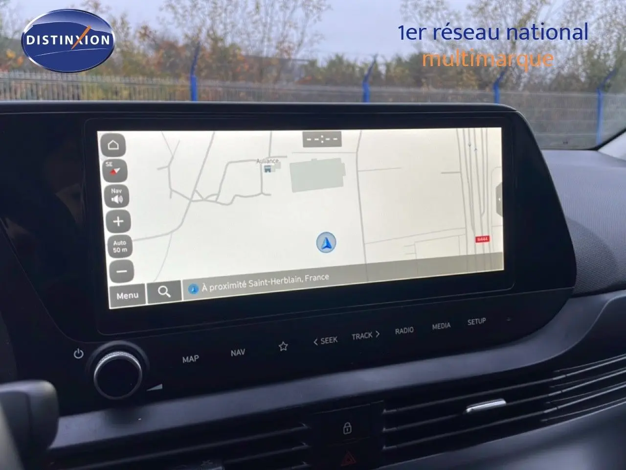 Vue intérieure centrée sur l'écran tactile du système de navigation de la Hyundai i20 rouge Dragon Metal 2025.