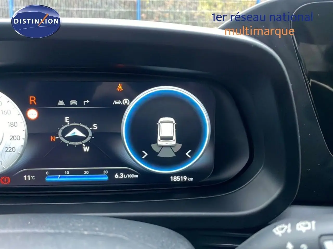 Affichage numérique du tableau de bord de la Hyundai i20 rouge Dragon Metal, montrant la caméra de recul et la consommation.