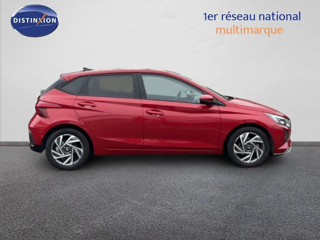 Vue profil droit d'une Hyundai i20 2025 rouge Dragon Metal avec jantes alliage et lignes dynamiques.