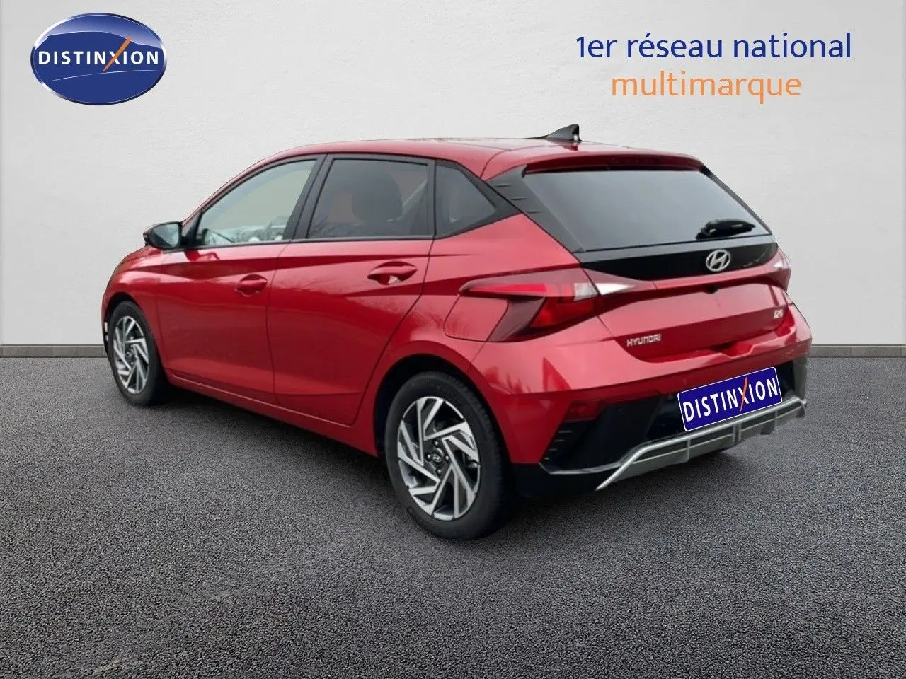 Vue 3/4 arrière droite d'une Hyundai i20 2025 rouge Dragon Metal avec jantes alliage et feux LED distinctifs.