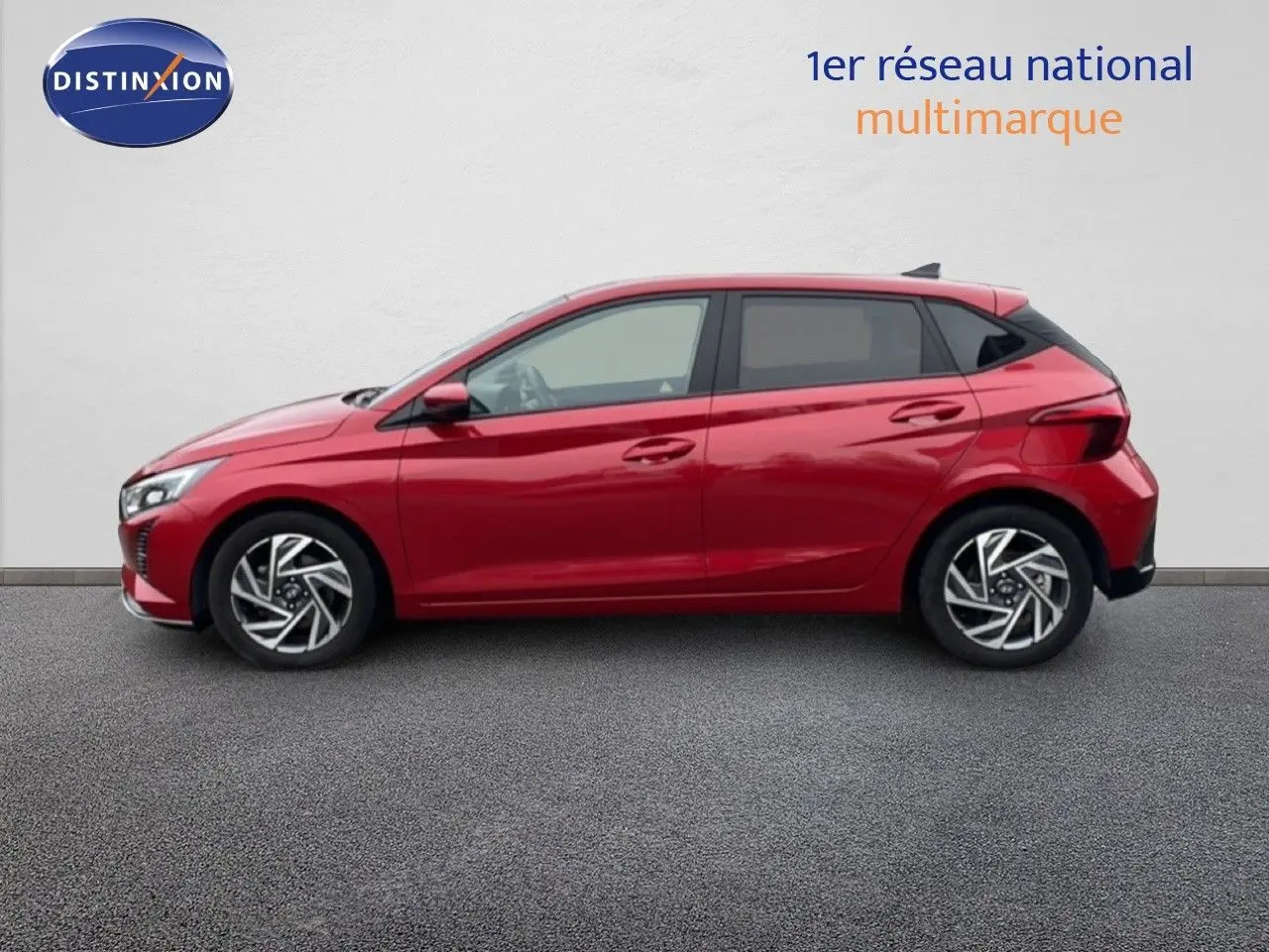 Vue latérale droite d'une Hyundai i20 2025 rouge Dragon Metal avec jantes alliage et lignes dynamiques.