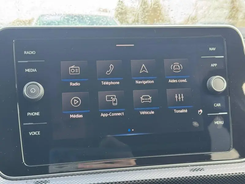 Écran tactile central du Volkswagen T-Cross 2025 affichant les options radio, téléphone, navigation et aides à la conduite.