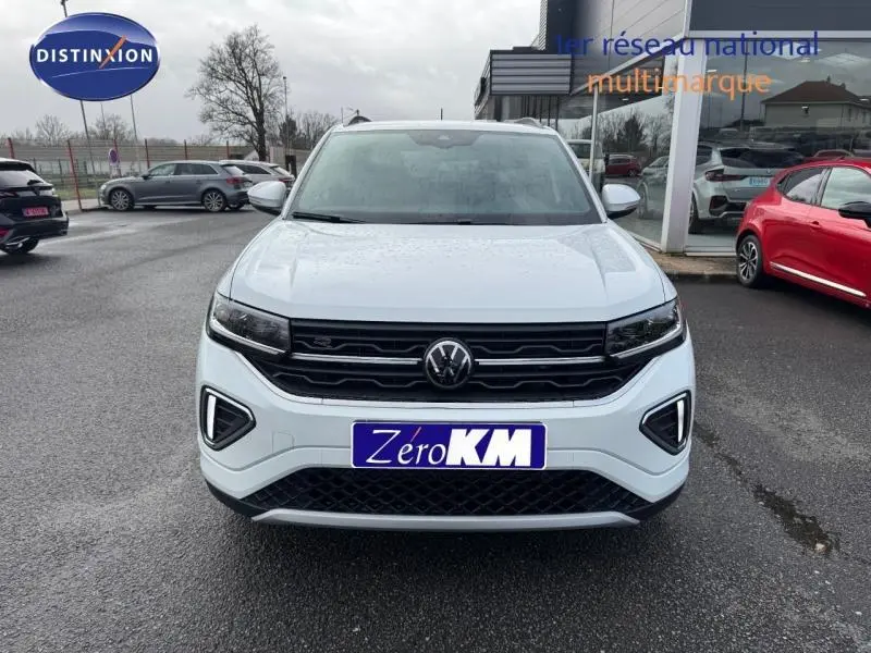 Vue de face d'un Volkswagen T-Cross 1.0 TSI 116ch R-Line blanc pur 2025 avec calandre noire et feux LED allumés.