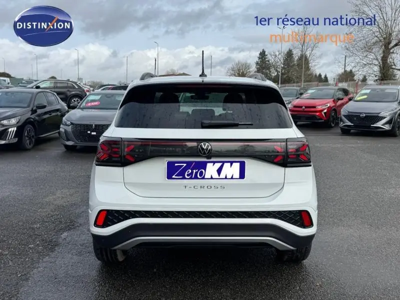 Vue arrière d’un Volkswagen T-Cross blanc Pur 2025 avec feux arrière LED et logo central sur parking.