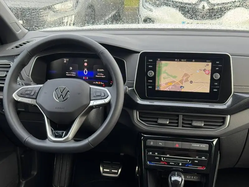 Vue intérieure du tableau de bord du Volkswagen T-Cross 2025 avec volant multifonction et écran tactile de navigation.