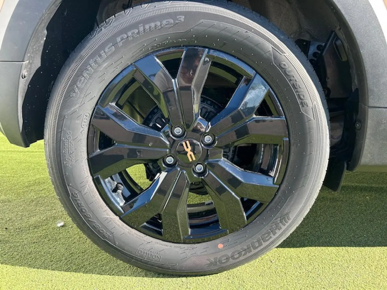 Gros plan sur la jante noire brillante 16 pouces Mahalia du Dacia Sandero Stepway Beige Safari, avec pneu Hankook.