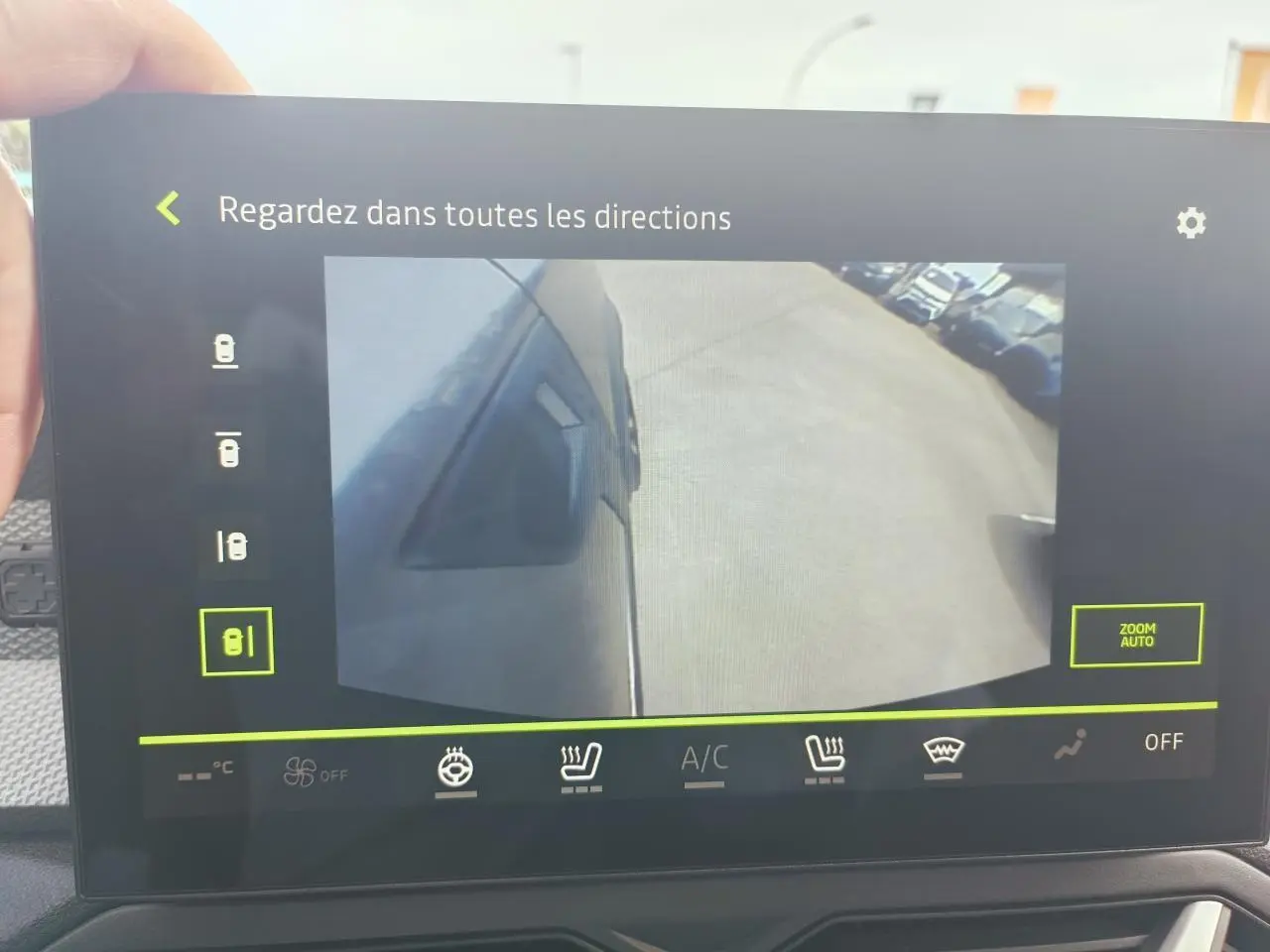 Vue caméra latérale gauche du Dacia Duster gris schiste, montrant le côté du véhicule et le sol adjacent.