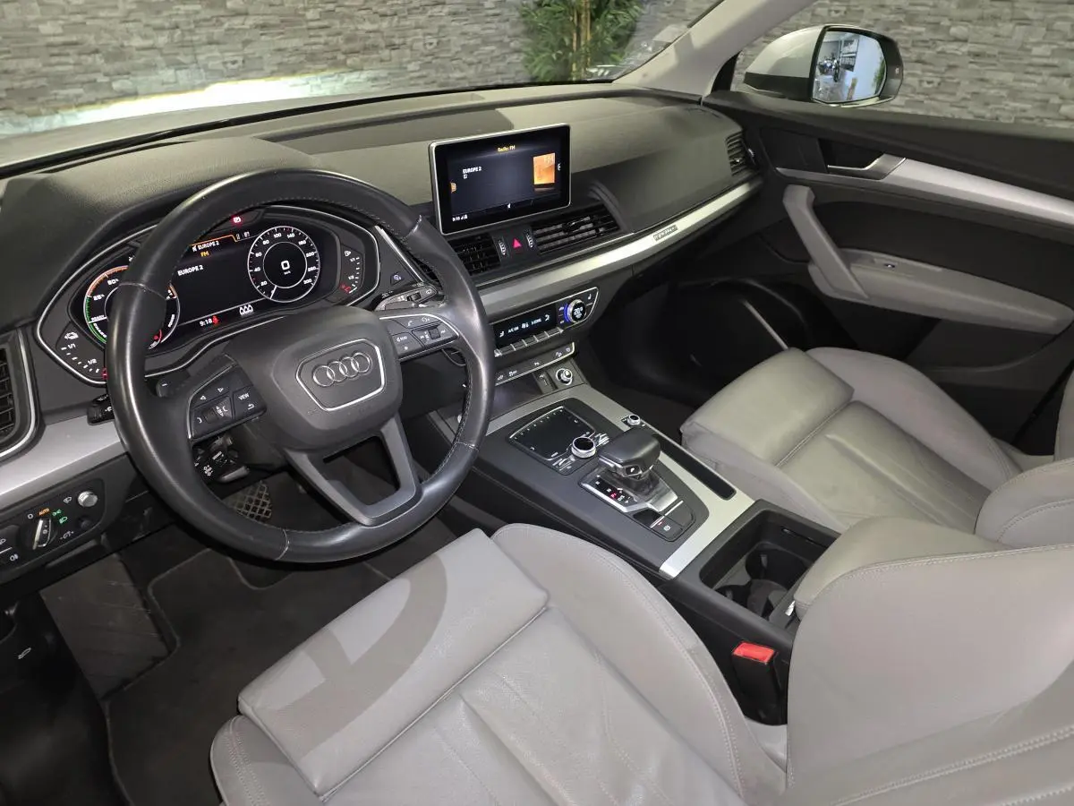 Vue intérieure côté conducteur de l'Audi Q5 gris avec sellerie cuir gris Roche et tableau de bord moderne.