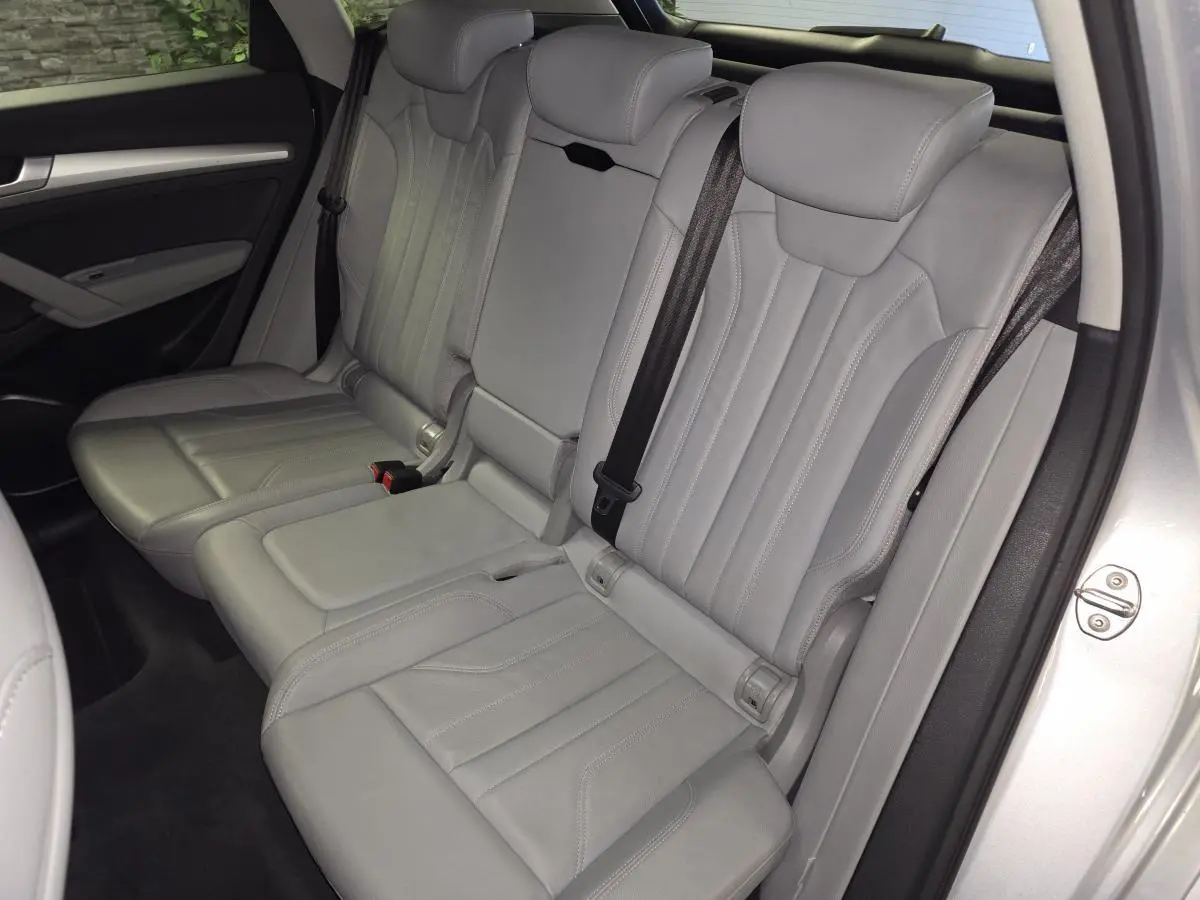 Vue latérale des sièges arrière en cuir gris Roche de l'Audi Q5 hybride rechargeable 2019, avec accoudoir central déplié.