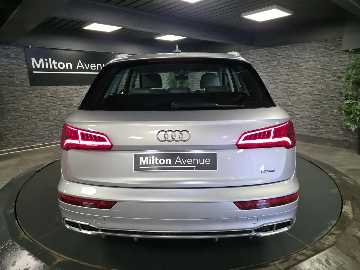Vue arrière d'un Audi Q5 gris métallisé avec feux LED dynamiques et double sortie d'échappement intégrée.