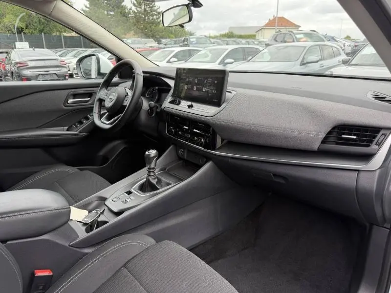 Vue intérieure côté conducteur du Nissan Qashqai 2025, tableau de bord moderne avec écran tactile et volant multifonction cuir.