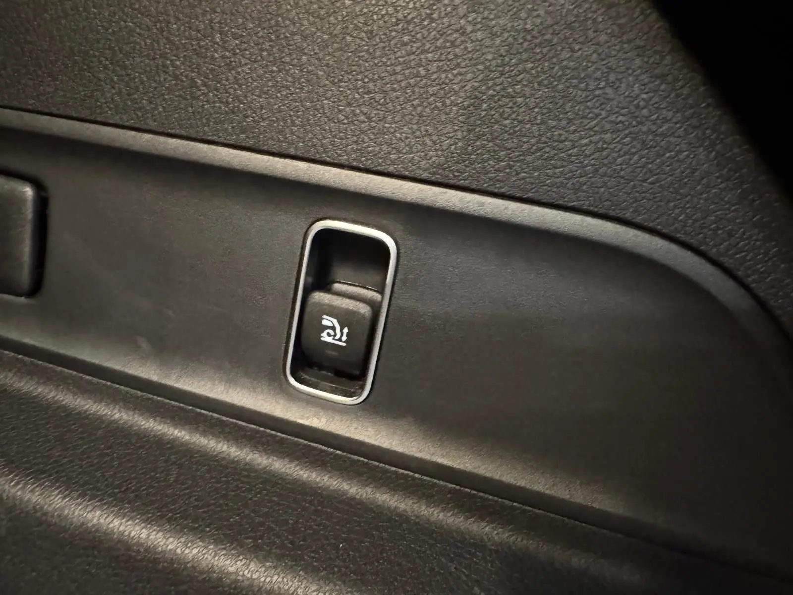 Détail du bouton d'ouverture électrique du hayon sur l'intérieur noir d'un Mercedes GLE 400 E HYBRID AMG 2023.
