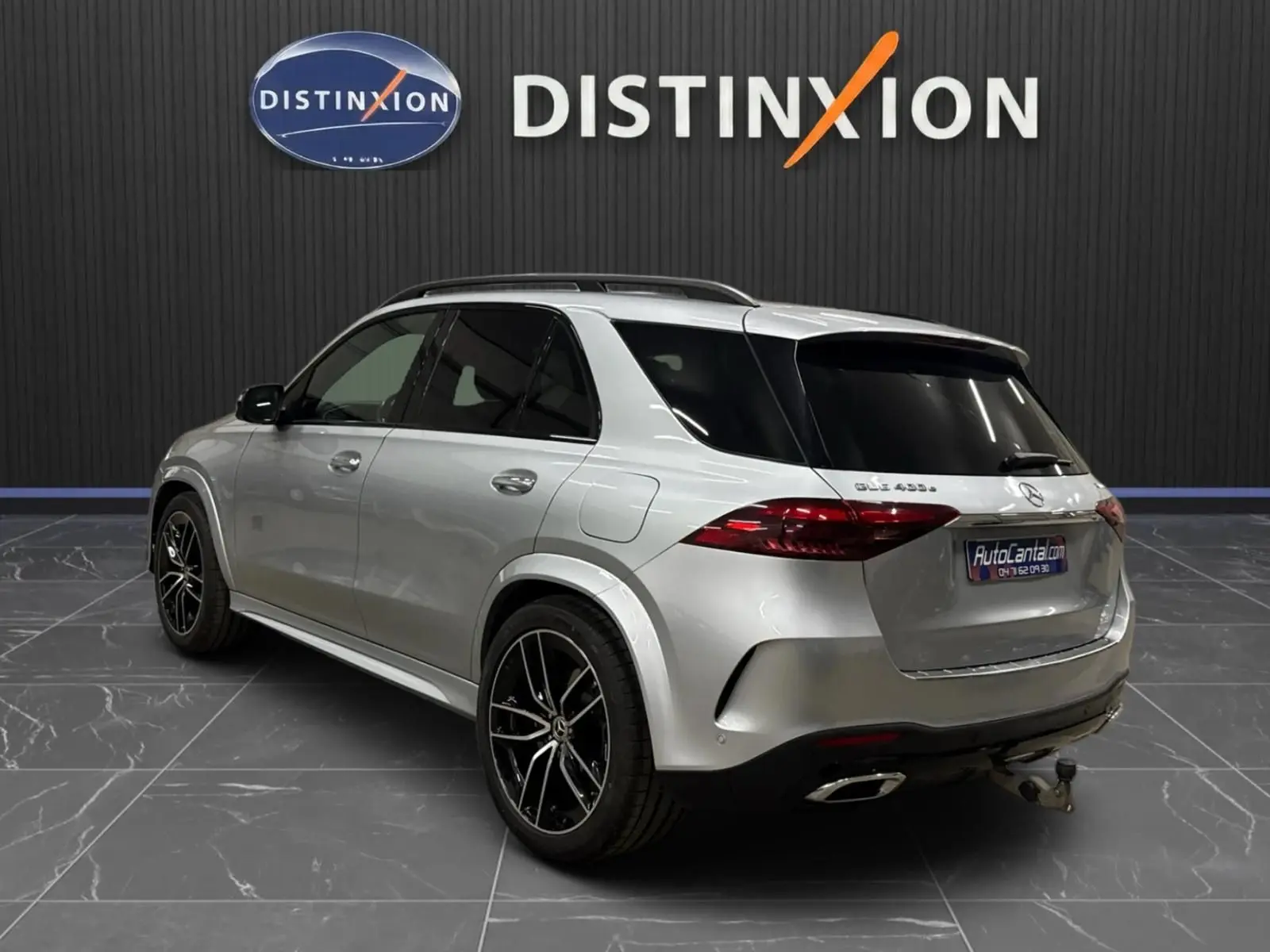 Mercedes GLE 400 E Hybrid AMG Line argent métallisé, vue 3/4 arrière droit avec jantes noires et attelage visible.