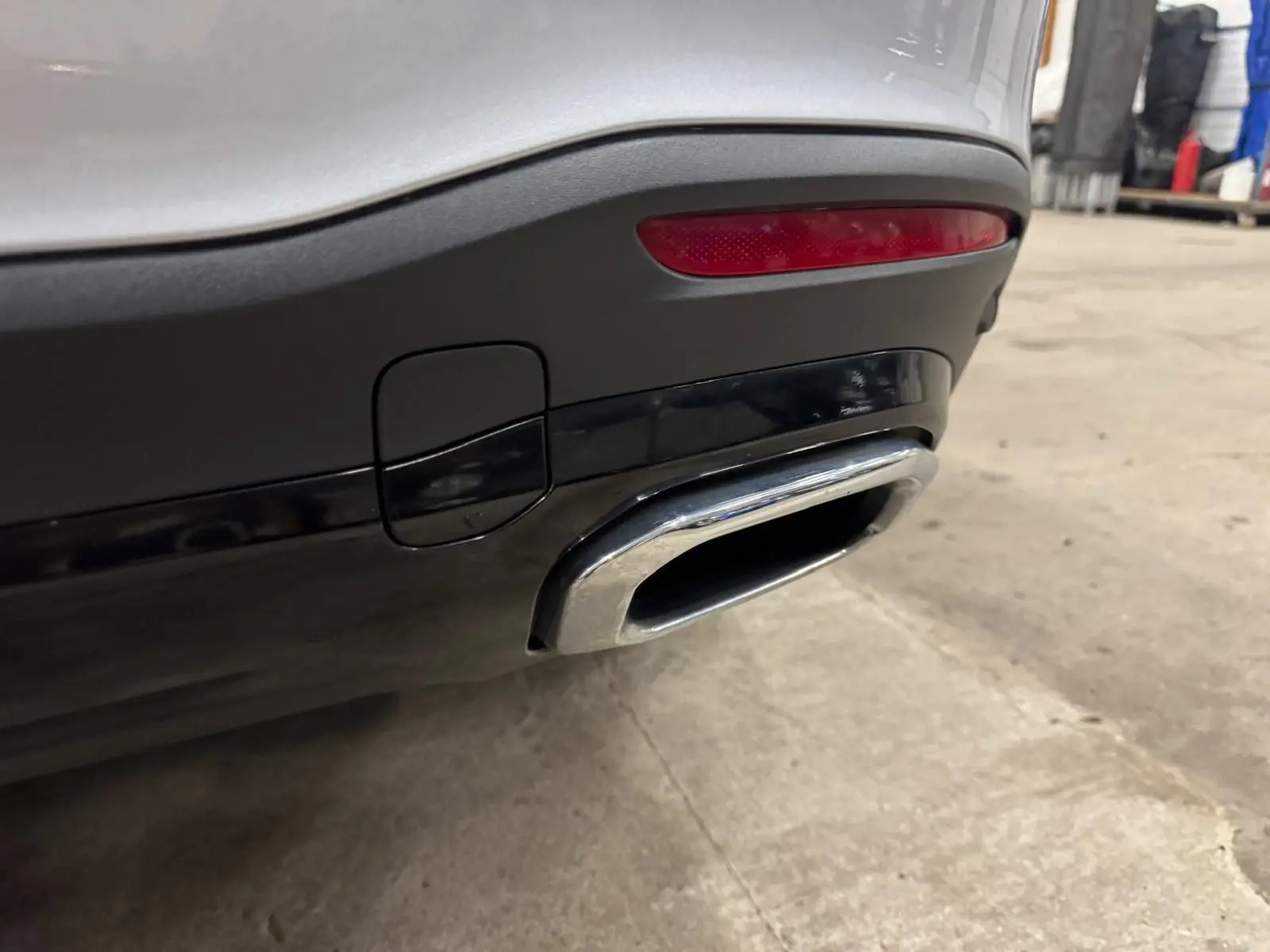 Gros plan sur la sortie d’échappement chromée arrière droite d’un Mercedes GLE 400 E Hybrid argent High-tech métallisé.
