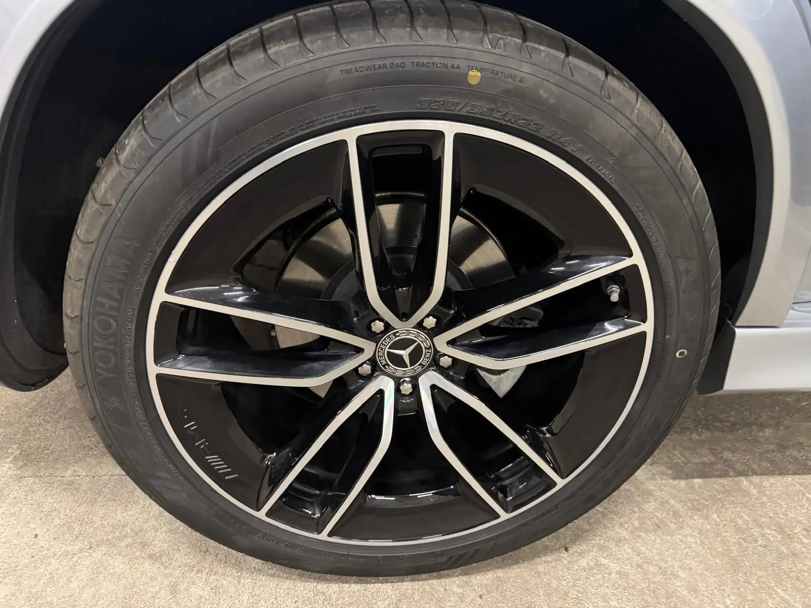Gros plan sur la jante noire et argentée du Mercedes GLE 400 E Hybrid AMG Line, avec pneu Yokohama, côté droit argent High-tech.
