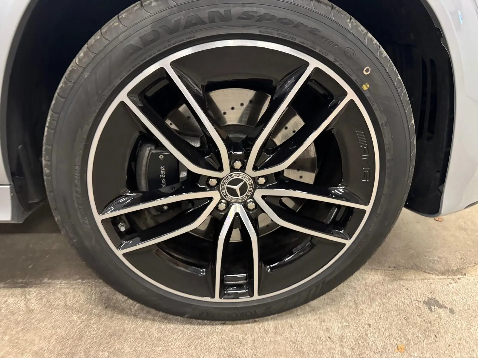 Gros plan sur la jante AMG noire et argentée d'un Mercedes GLE 400 E Hybrid argent High-tech, avec logo Mercedes au centre.