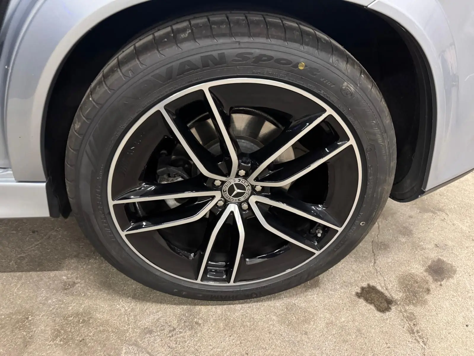 Gros plan sur la roue avant droite argent High-tech métallisé du Mercedes GLE 400 E HYBRID AMG Line 2023 avec jante noire et argent.