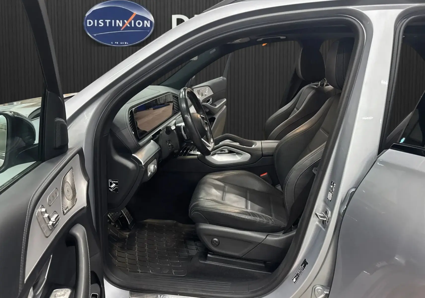 Intérieur côté conducteur d’un Mercedes GLE 400 E Hybrid AMG Line 2023 argent, sièges cuir noir et tableau de bord moderne.