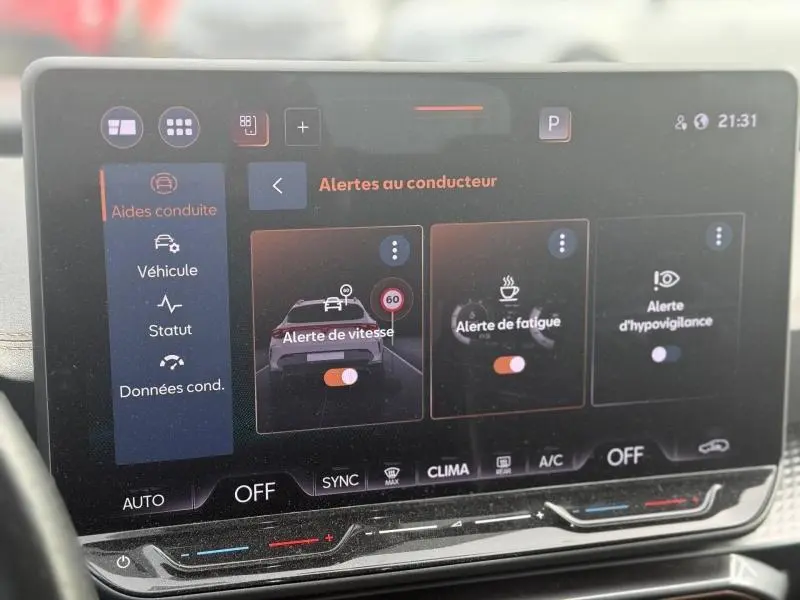 Écran tactile intérieur de la CUPRA Formentor bleu, affichant les alertes au conducteur et commandes climatisation.