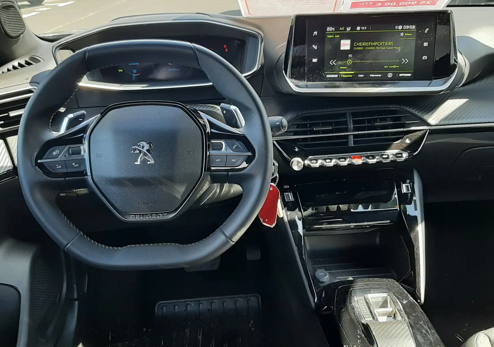 Intérieur Peugeot 2008 2023 vue du conducteur, tableau de bord noir avec écran tactile et volant compact multifonctions.