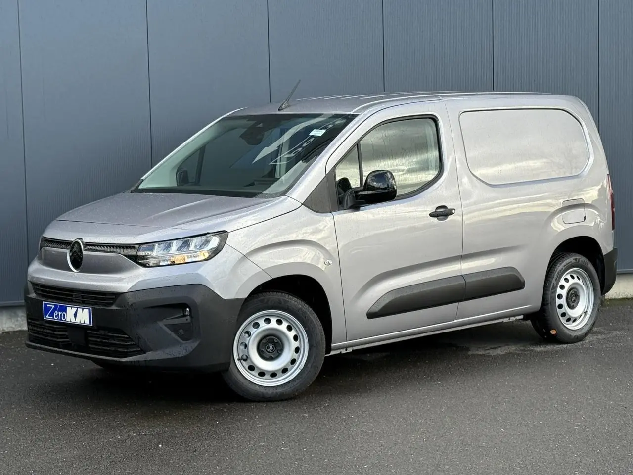 Vue 3/4 avant droit du Citroën Berlingo Van gris Artense avec jantes tôles et pare-chocs noirs.