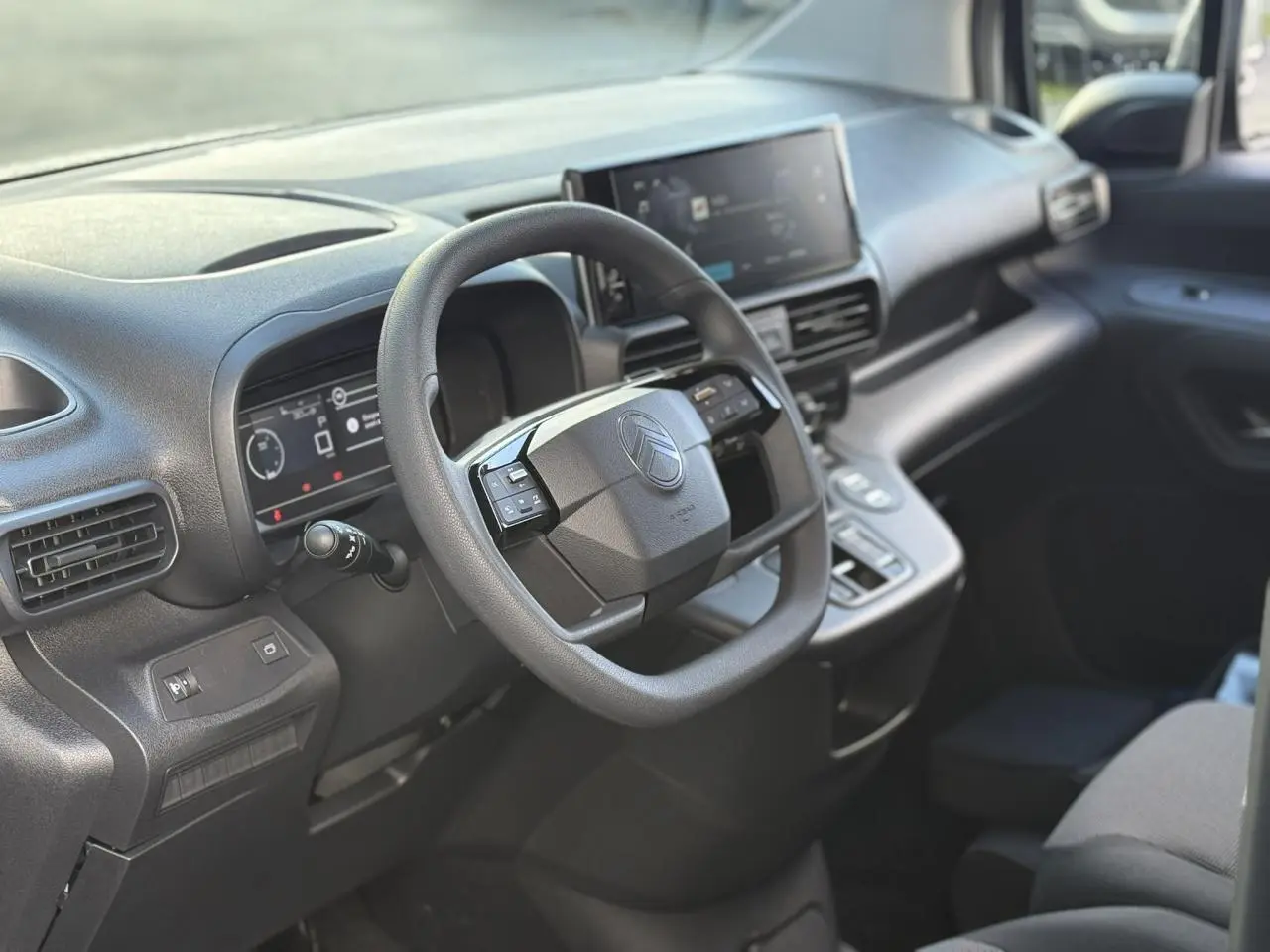 Intérieur du Citroën Berlingo 2025, vue côté conducteur sur le tableau de bord et volant multifonctions noir.