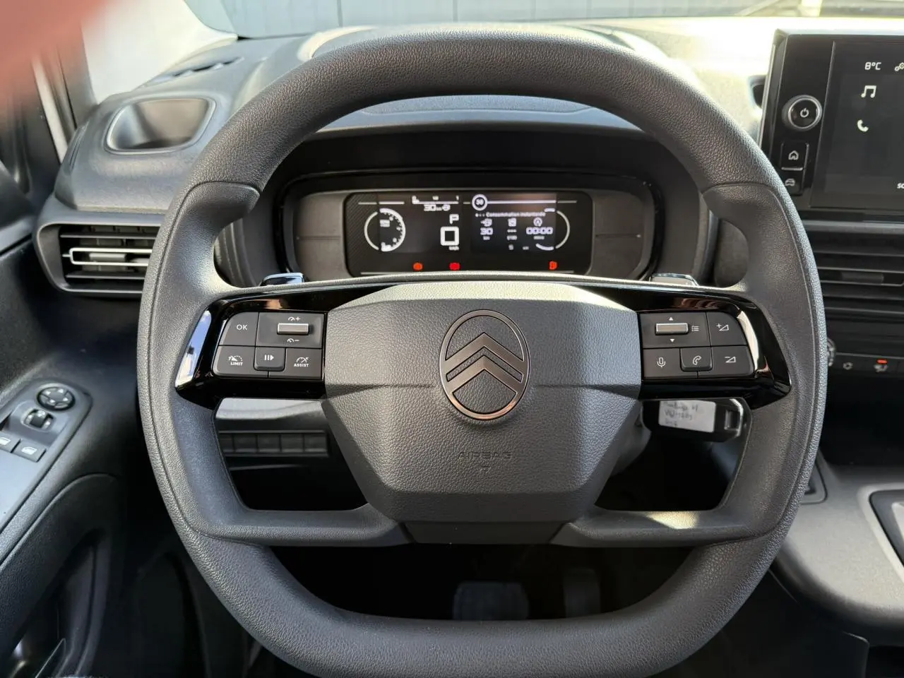 Vue rapprochée du volant multifonctions Citroën Berlingo 2025 avec tableau de bord numérique et commandes intégrées.