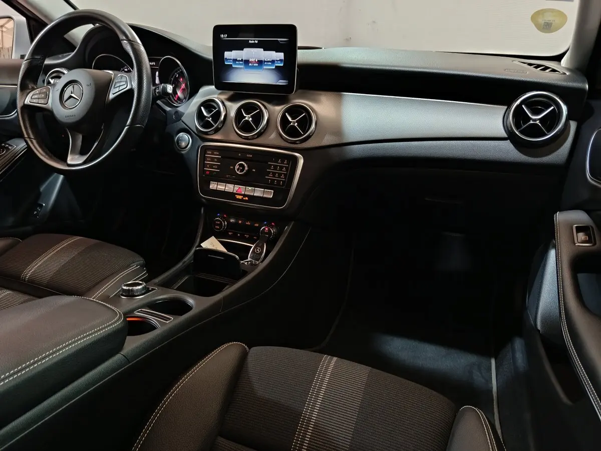 Intérieur noir du Mercedes GLA 200 d 2018, vue du tableau de bord avec écran central et volant multifonctions cuir.