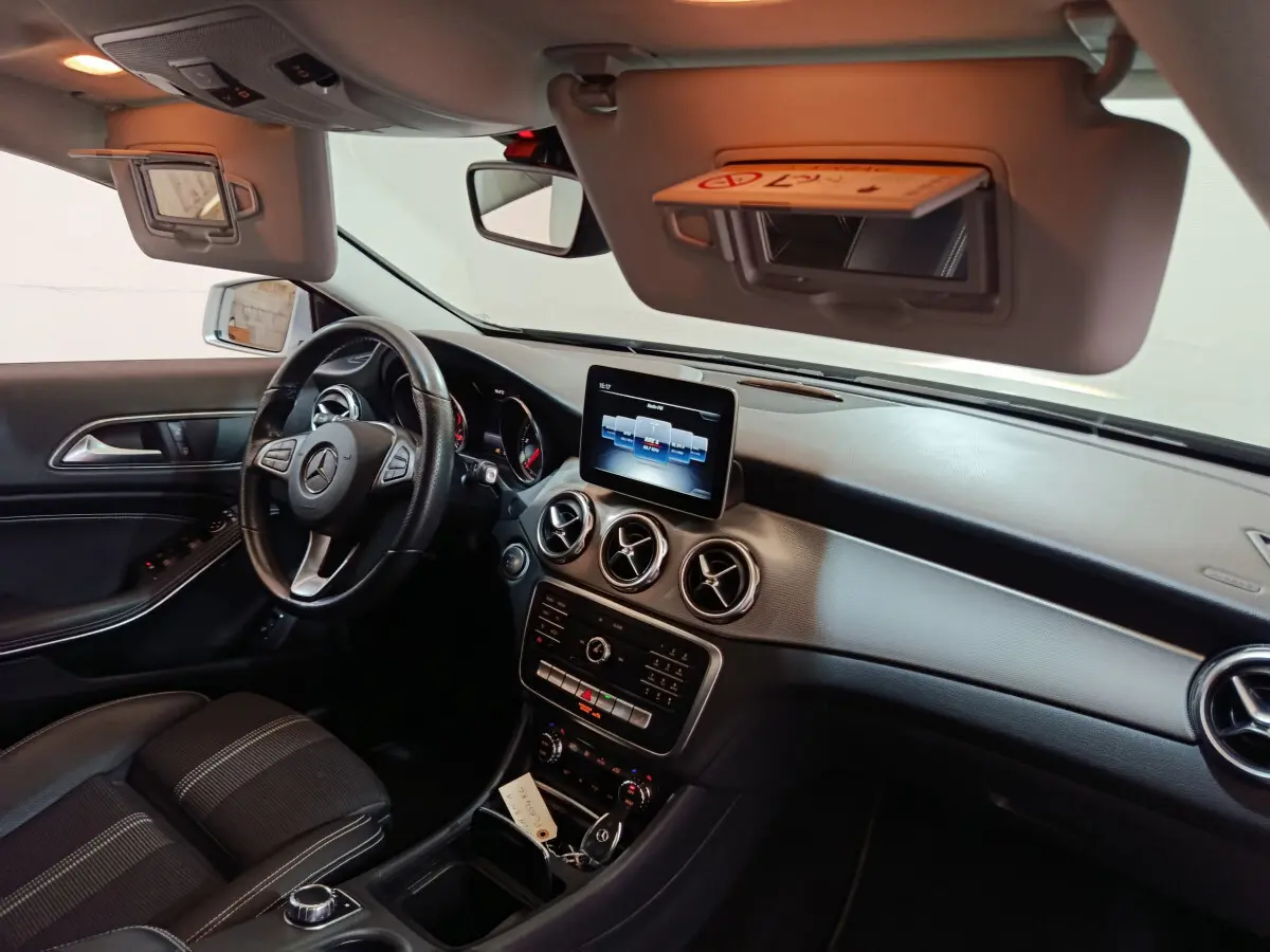Intérieur noir du Mercedes GLA 200 d 2018 vu côté conducteur, tableau de bord avec écran central et volant cuir multi-fonctions.