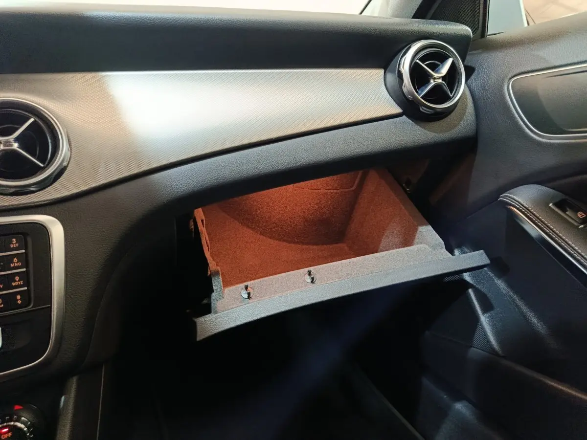 Vue intérieure côté passager du tableau de bord noir et boîte à gants ouverte du Mercedes GLA 200 d Business Executive 2018.