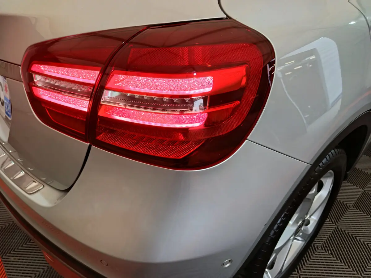 Gros plan sur le feu arrière droit allumé d'un Mercedes GLA 200 d Business Executive gris clair, avec jante visible.