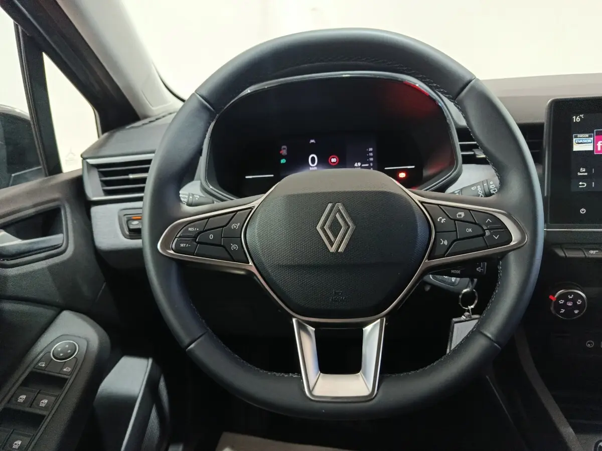 Vue rapprochée du volant cuir noir de la Renault Clio 2025 avec commandes multifonctions et tableau de bord numérique.