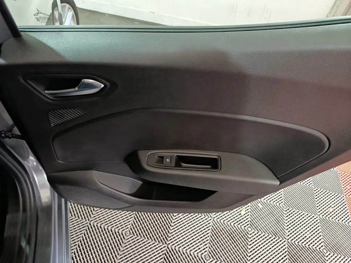 Vue rapprochée de la porte côté gauche gris clair de la Renault Clio Evolution Blue dCi 100 avec poignée intérieure noire.