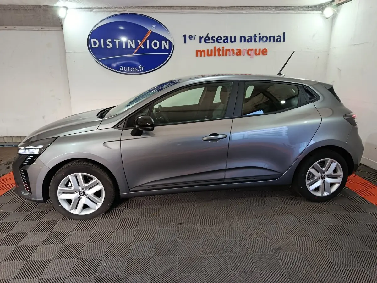 Profil droit d'une Renault Clio gris clair 2025 Evolution Blue dCi 100, avec jantes alliage et feux LED avant visibles.
