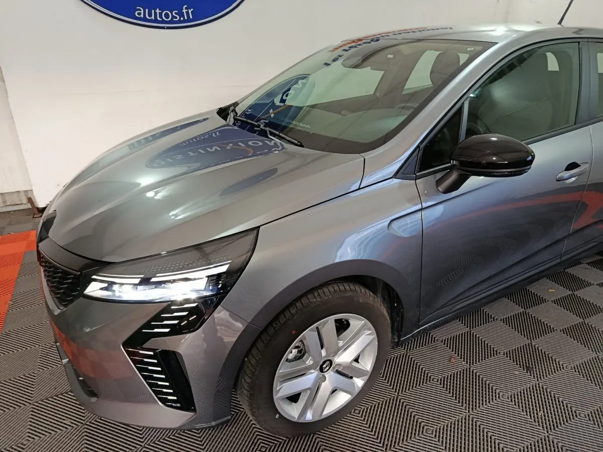 Vue 3/4 avant droit d'une Renault Clio Evolution Blue dCi 100 gris clair avec feux LED et jantes alliage.