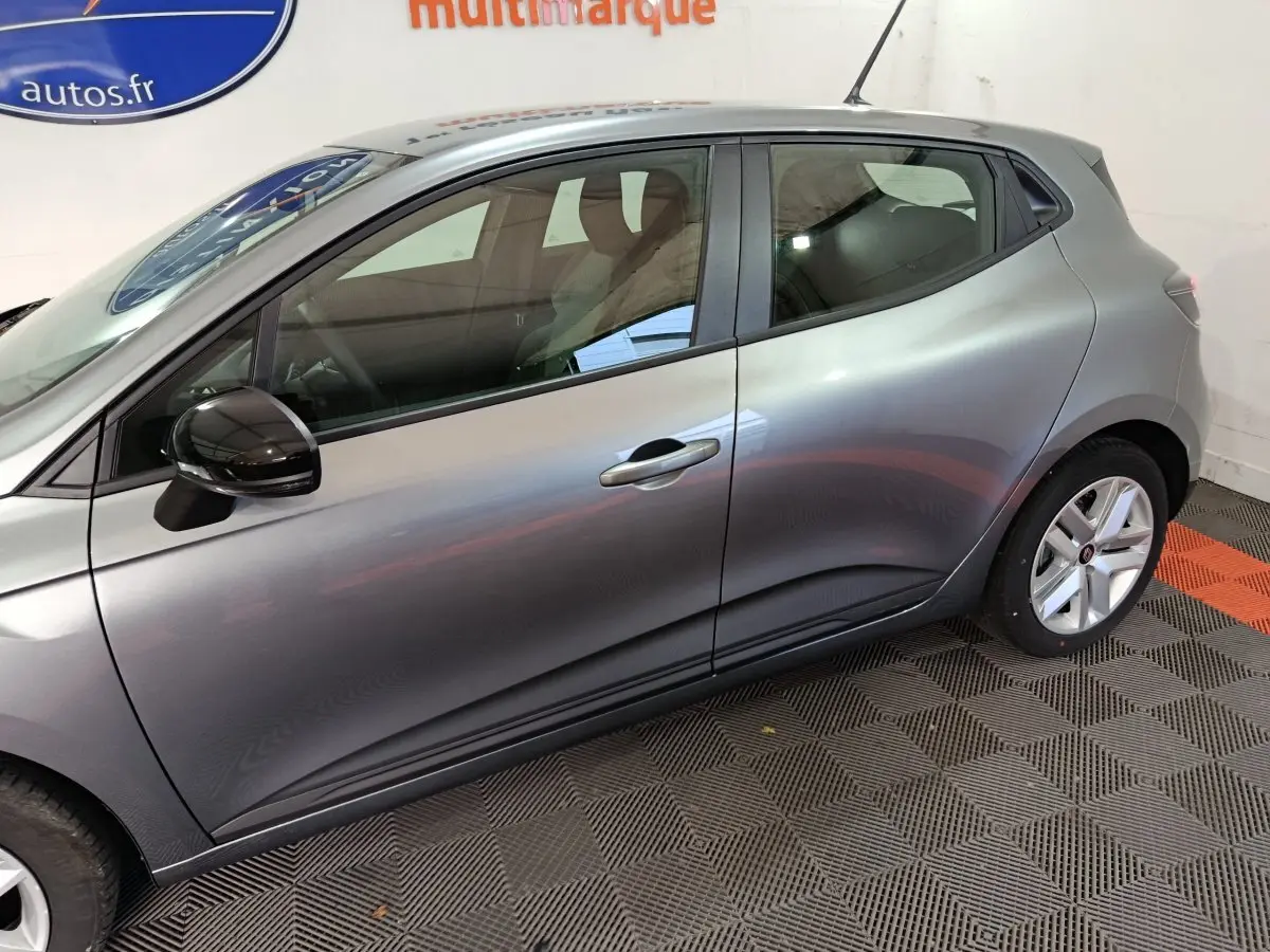 Profil droit de la Renault Clio Evolution Blue dCi 100 gris clair 2025, avec rétroviseur noir et jantes alliage.