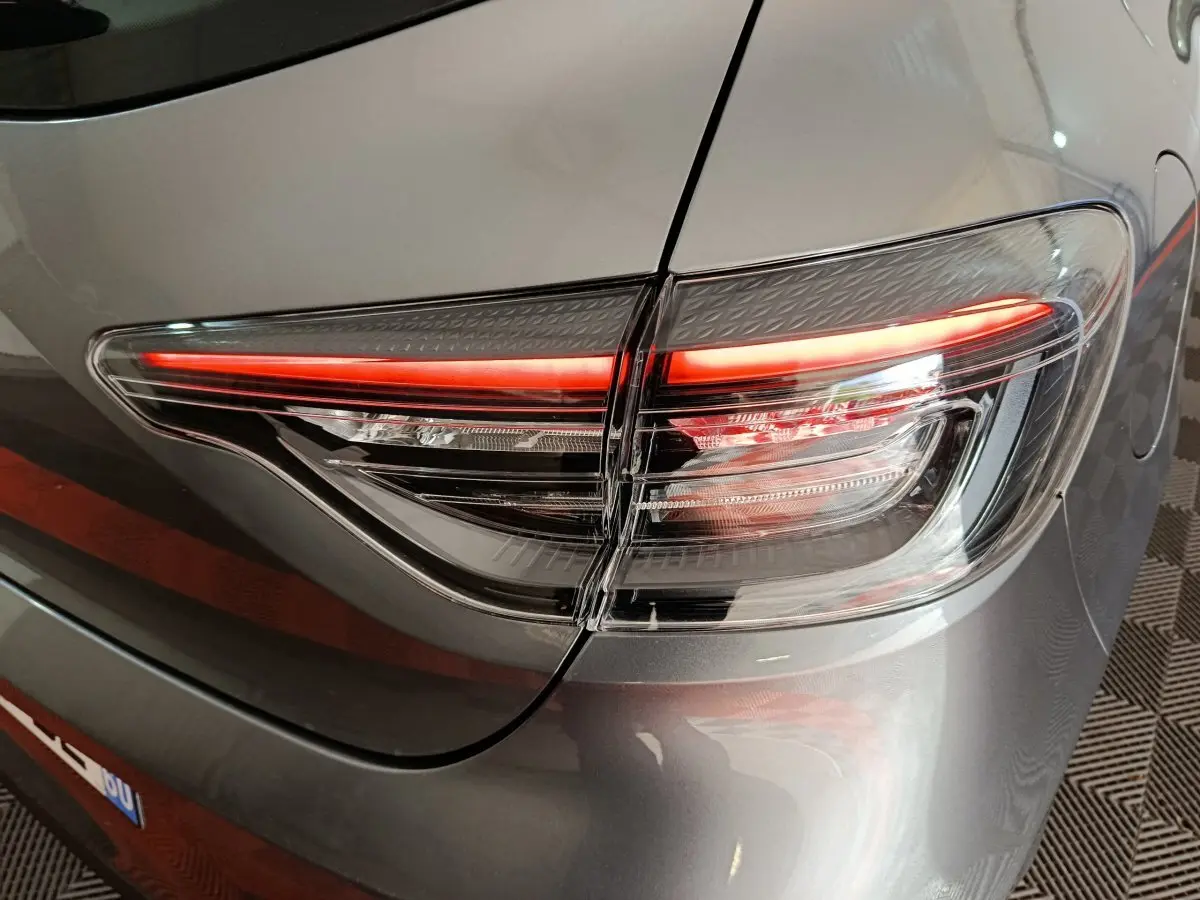 Gros plan sur le feu arrière droit allumé d'une Renault Clio Evolution Blue dCi 100 gris clair de 2025.