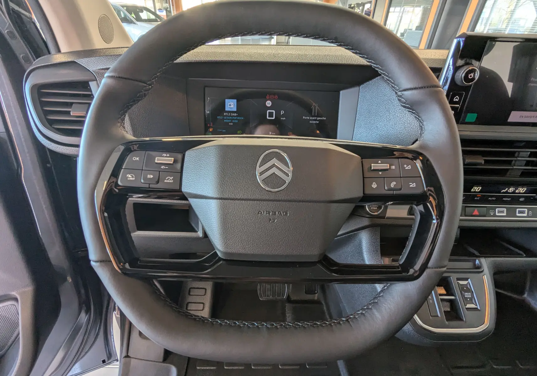 Vue rapprochée du volant cuir noir du Citroën Jumpy Cabine Approfondie gris titane avec tableau de bord digital.