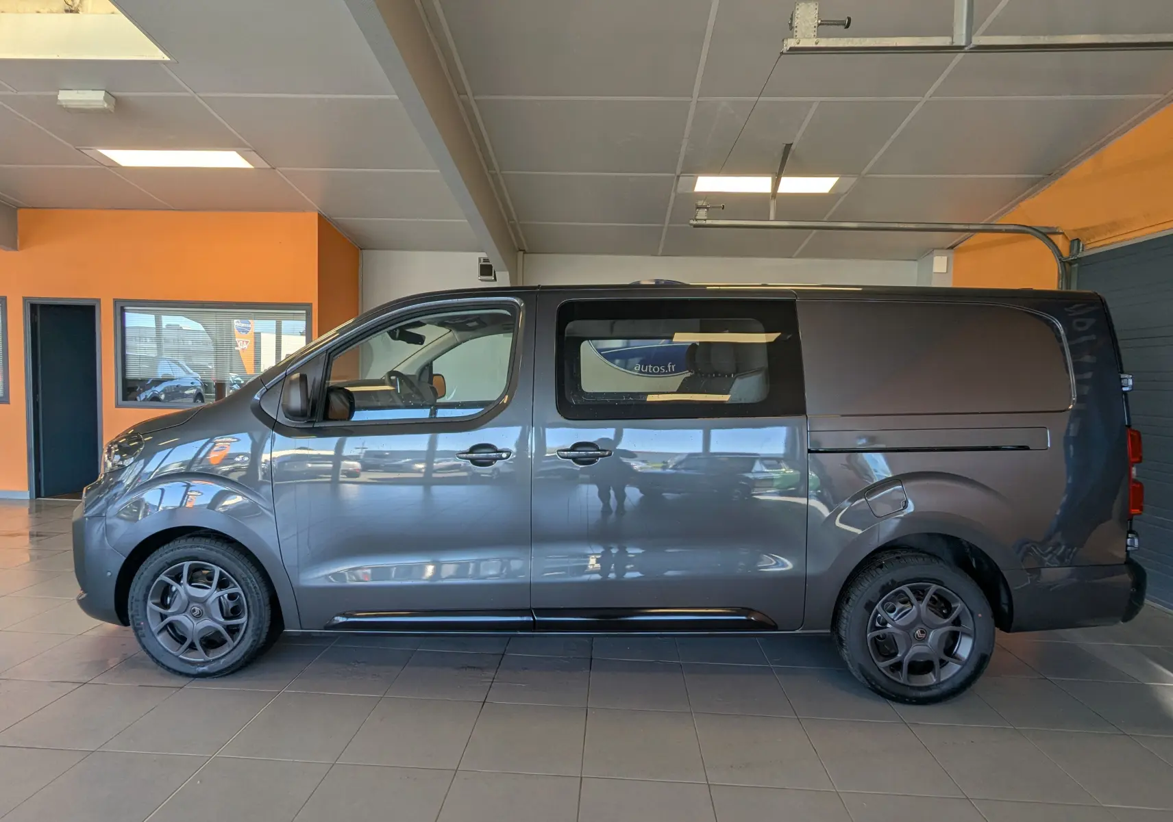Vue latérale gauche d'un Citroën Jumpy Cabine Approfondie gris titane 2026 avec fenêtre arrière et jantes spécifiques.