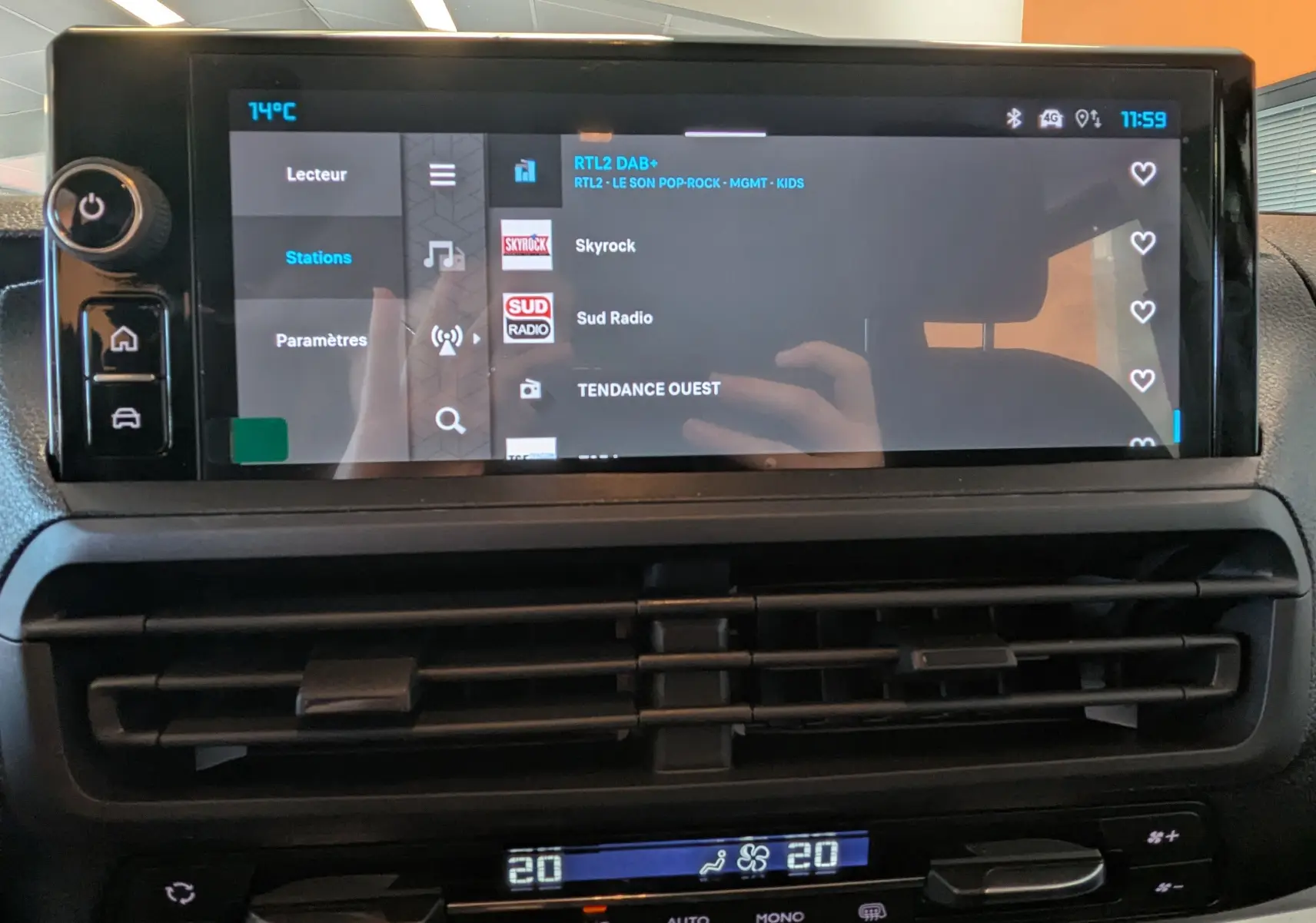 Écran tactile central du tableau de bord du Citroën Jumpy gris titane, affichant les stations radio avec commandes climatisation en dessous.