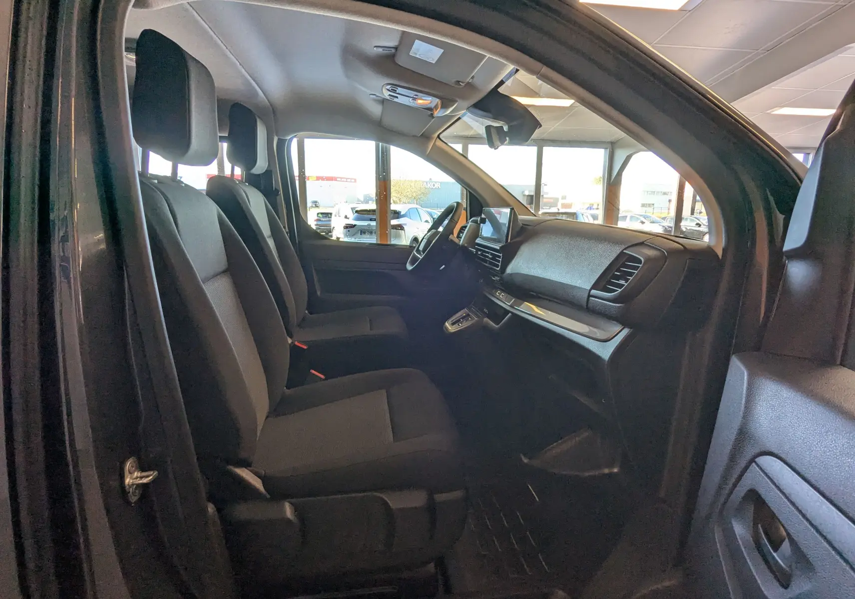 Vue intérieure côté gauche du Citroën Jumpy Cabine Approfondie 2026 gris titane, montrant les sièges avant et le tableau de bord.