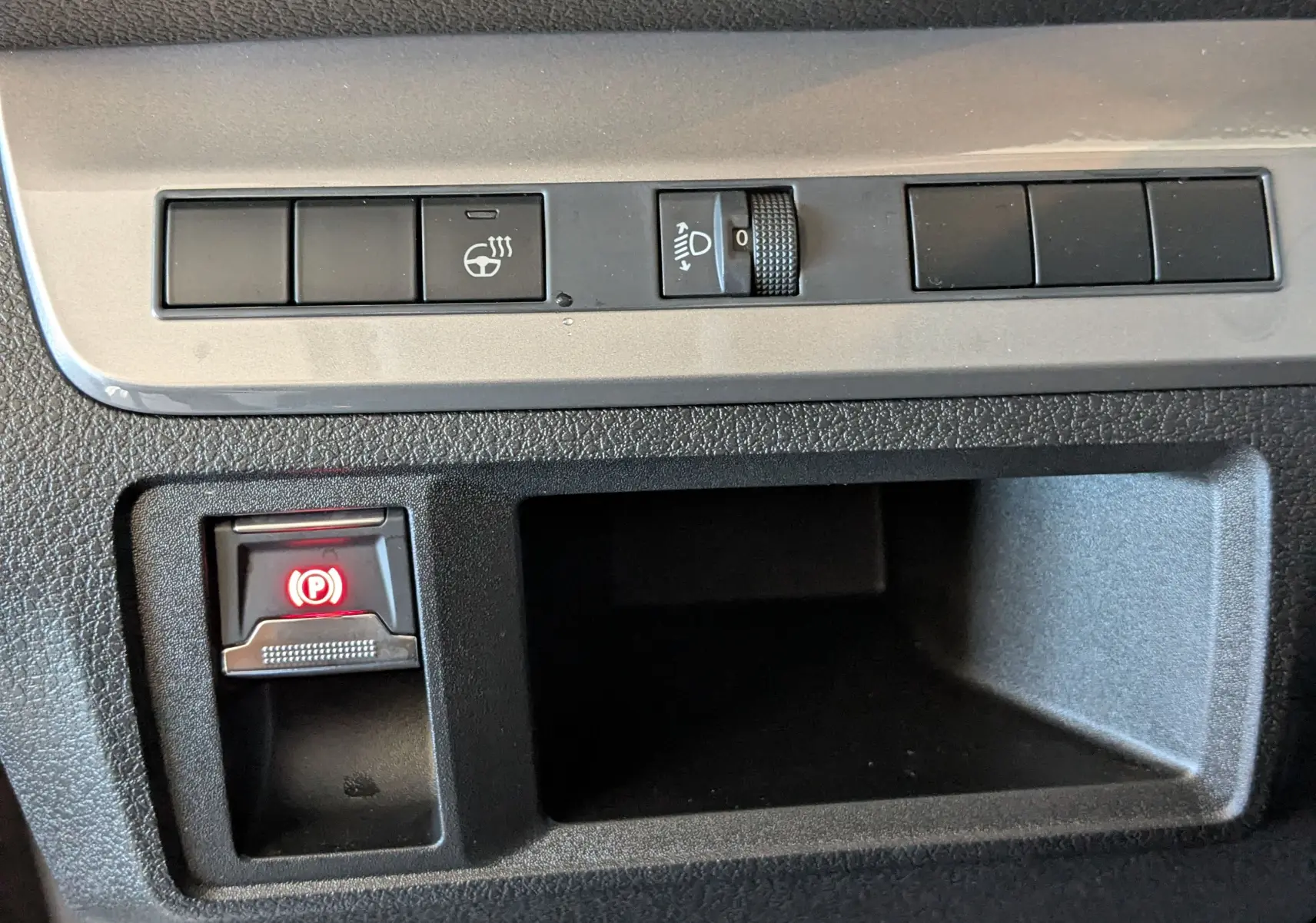 Gros plan sur les commandes intérieures du Citroën Jumpy Cabine Approfondie gris titane, avec bouton de frein à main électrique allumé.